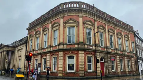 BBC/Naj Modak A vacant two-storey building in York, which stretches around a corner and is situated near a set of traffic lights.