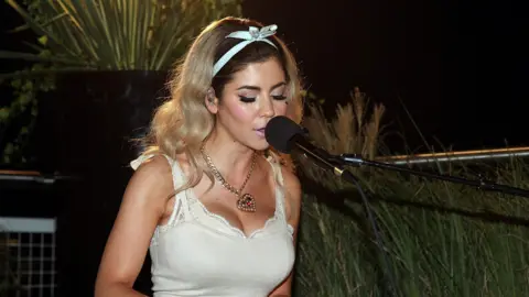 Getty Images Mar ina Diamandis performing as Marina and the Diamonds, singing at a piano