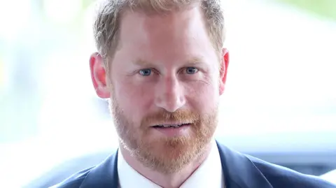 Getty Images Prince Harry in a white shirt and blue jacket