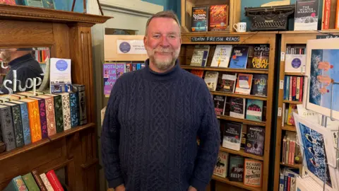 BBC A man in front of a display of books