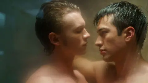 Sabrina Lantos/HBO Max Connor Storrie and Hudson Williams seen in a still from Heated Rivalry facing each other, head and shoulders, in a steamy shower scene